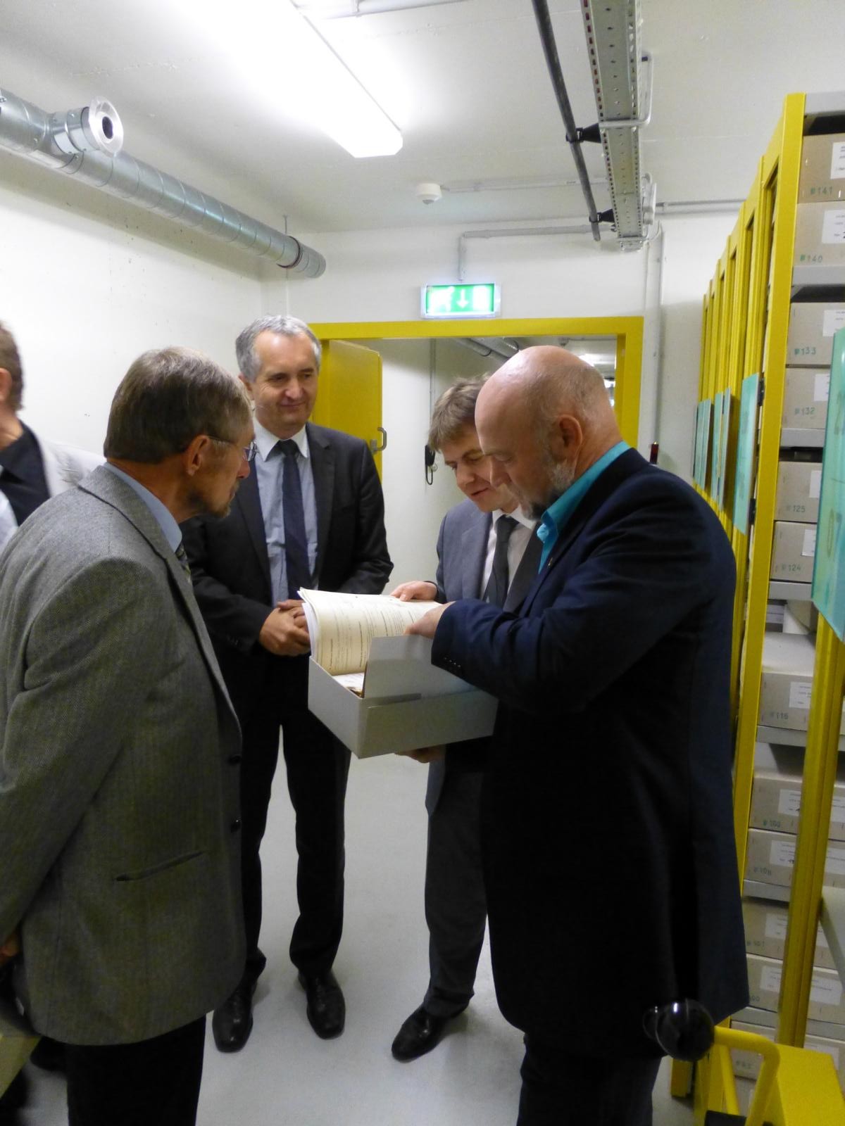 Die Landtagsabgeordneten Gernot Krasselt, Thomas Schmidt und Andreas Heinz lassen sich von Raymond Plache die Aufbewahrung des Archivgutes erklären.